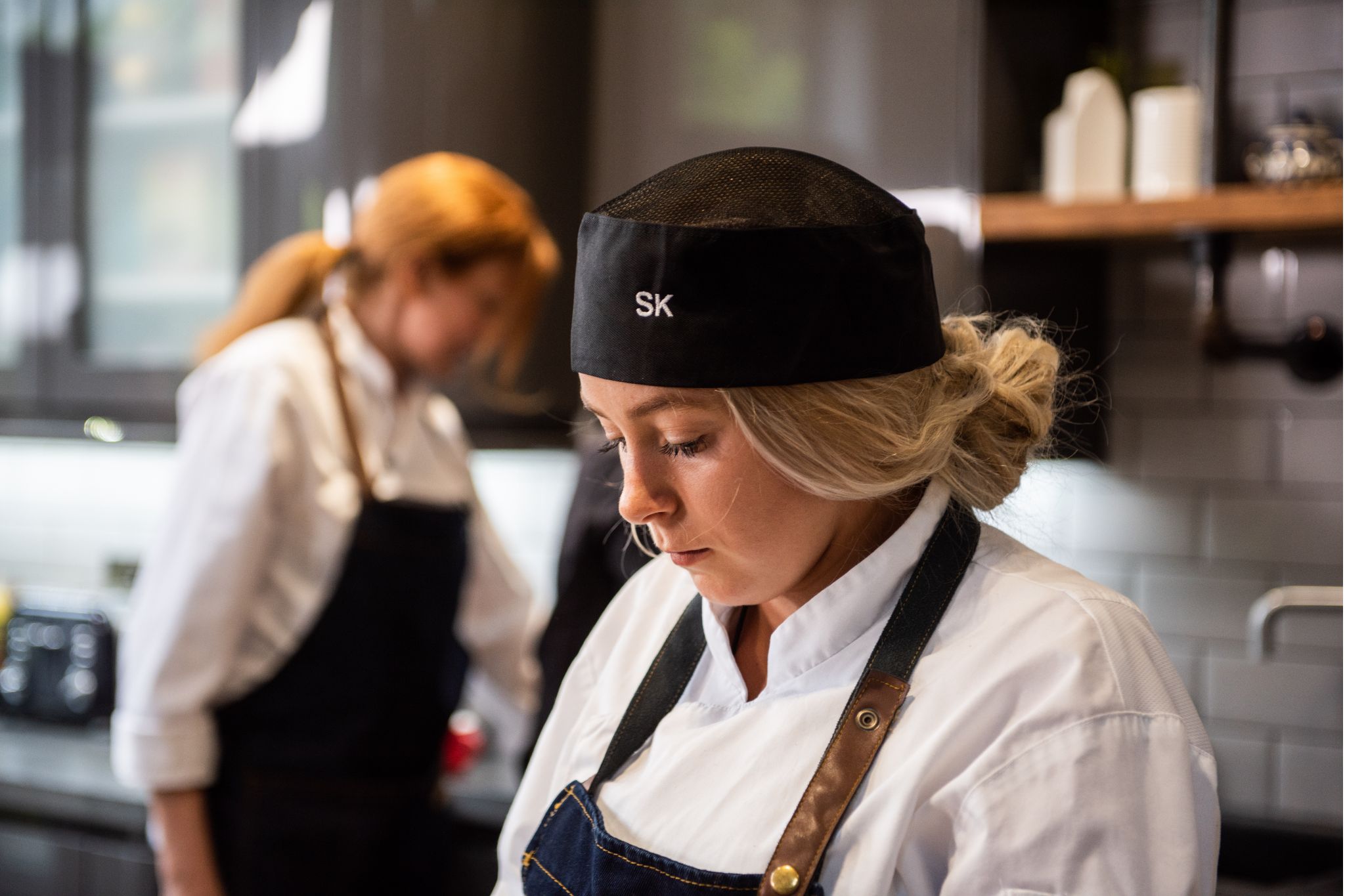 Chef preparing food in a kitchen during a hands-on sustainability training session.